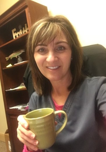 Doctor Mason in her dental office holding a coffee mug